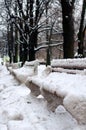Benches in the park, covered with snow. Vertical view Royalty Free Stock Photo