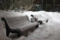 Benches in the park covered with snow.