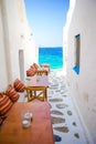Benches with pillows in a typical greek bar in Mykonos with amazing sea view on Cyclades islands Royalty Free Stock Photo