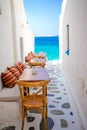 Benches with pillows in a typical greek bar in Mykonos with amazing sea view on Cyclades islands Royalty Free Stock Photo