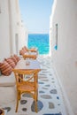 Benches with pillows in a typical greek outdoor cafe in Mykonos with amazing sea view on Cyclades islands Royalty Free Stock Photo