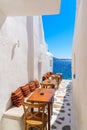 Benches with pillows in a typical Greek bar in Mykonos town with sea view, Cyclades islands, Greece Royalty Free Stock Photo