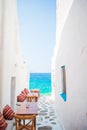 Benches with pillows in a typical greek outdoor cafe in Mykonos with amazing sea view on Cyclades islands Royalty Free Stock Photo