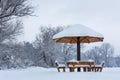 Benches with roof in the form of mushrooms covered with snow on cold winter day