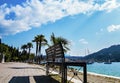 Benches on the shore of Lake Garda, Italy overlooking the exclusive yacht morrings and distant mountains Royalty Free Stock Photo