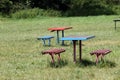 Benches and a trash bin in the grass outside in nature