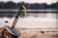 Benchmade bushcrafter, knife dug into a log against a blurred view of a lake Royalty Free Stock Photo