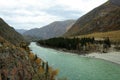 A bend of a beautiful turquoise river flowing through an autumn valley surrounded by a mountain range Royalty Free Stock Photo