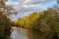 A bend in the Neuse River in Raleigh, North Carolina in autumn with the sun shining on the orange leaves of the trees