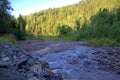 The bend of a small mountain river flowing in rocky shores through the morning forest Royalty Free Stock Photo