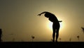 Bend yoga pose, silhouette of woman exercising and meditating against sunset Royalty Free Stock Photo