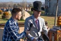 Organ grinder in a hat and round glasses gives an interview on an autumn sunny day in the