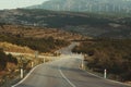 Bending country road with windmills on the hills Royalty Free Stock Photo