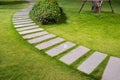 Bending garden stone path at night with glowing light from garden outdoor light Royalty Free Stock Photo