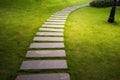 Bending garden stone path at night with glowing light from garden outdoor light Royalty Free Stock Photo