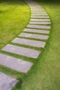 Bending garden stone path at night with glowing light from garden outdoor light Royalty Free Stock Photo