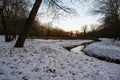 The bending Molenbeek creek through the park, covered with snow at dusk, Jette, Belgium