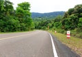 Bending Road to the Top of a Mountain with Green Trees and Traffic Signs Royalty Free Stock Photo