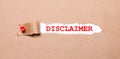 Beneath the torn strip of kraft paper attached with a red button is a white paper labeled DISCLAIMER Royalty Free Stock Photo