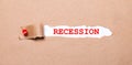 Beneath the torn strip of kraft paper attached with a red button is a white paper labeled RECESSION Royalty Free Stock Photo