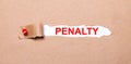 Beneath the torn strip of kraft paper attached with a red button is a white paper PENALTY