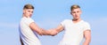 Benefits of having twin brother. Friendship and support. Men muscular twins brothers in white shirts sky background