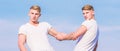 Benefits of having twin brother. Friendship and support. Men muscular twins brothers in white shirts sky background