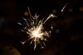 Bengal fire sparkles against the background of city lights, blurred bokeh. Royalty Free Stock Photo