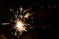Bengal fire sparkles against the background of city lights, blurred bokeh. A lot of sparks Royalty Free Stock Photo
