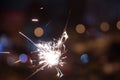 Bengal fire sparkles against the background of city lights, blurred bokeh. Royalty Free Stock Photo