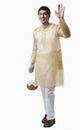 Bengali man carrying a pot of rasgulla and waving hand