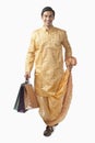 Bengali man carrying shopping bags and smiling