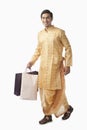 Bengali man carrying shopping bags and smiling