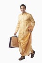 Bengali man carrying shopping bags and smiling