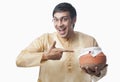 Bengali man pointing towards a pot of rasgulla