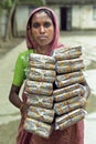 Bengali woman carries piles of cigarettes in factory