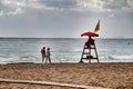 Beach watcher under red umbrella on the beach