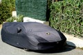 Benidorm, Spain - 06 April, 2023: Lamborghini car covered with black car protective awning. Lamborghini car under