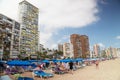 2021.08.18 Benidorm, Spain Beach near living buildings with sunbathing beds. People enjoy under sunshade. Royalty Free Stock Photo