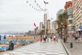 Tourists walking along the seafront of Levante beach in cloudy September weather