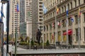 The Benito Juarez Statue along the Magnificent Mile with flags, people walking, lush green trees and plants, office buildings