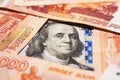 Benjamin Franklin on a hundred dollar bill surrounded by Russian rubles with a face value of five thousand each Royalty Free Stock Photo