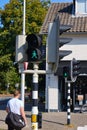 Bennekom,Netherlands,Aug,19,2020:Green pedestrian light with a walking happy girl with ponytail at crossroads in the