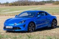 blue new Renault Alpine A110 car exhibited at the tour de france in small village contryside