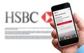 Man holding a smartphone in his hand with hsbc french signin page. Blurry HSBC logo of website on background