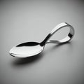 Bent Silver Spoon with Loop Handle on Gray Isolated Background a Polished Utensil with Unique Design and Elegant Curves for Royalty Free Stock Photo