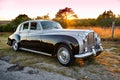 1960 Bentley shines with luster at sunset on a Texas hill country road.