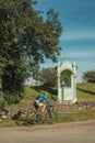 Cyclist on dirt road with a small roadside shrine