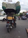 Bentor driver carrying a load exceeding its capacity. Bentor is public transportation in Gorontalo Province