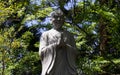 Monument of a Praying, buddhist monk. Green Vegetation in the background